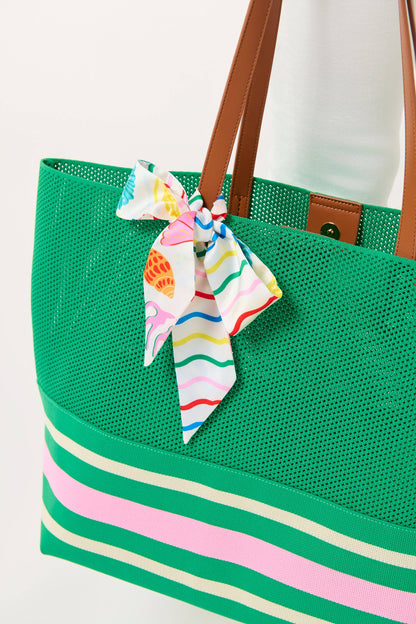 Green tote bag with striped base and colorful scarf, on a white background