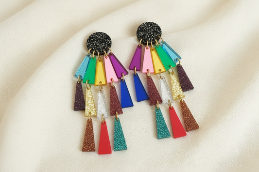 colorful acrylic earrings against an ivory fabric 