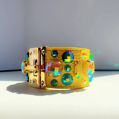 yellow leather bracelet with colorful gemstones on a light gray background