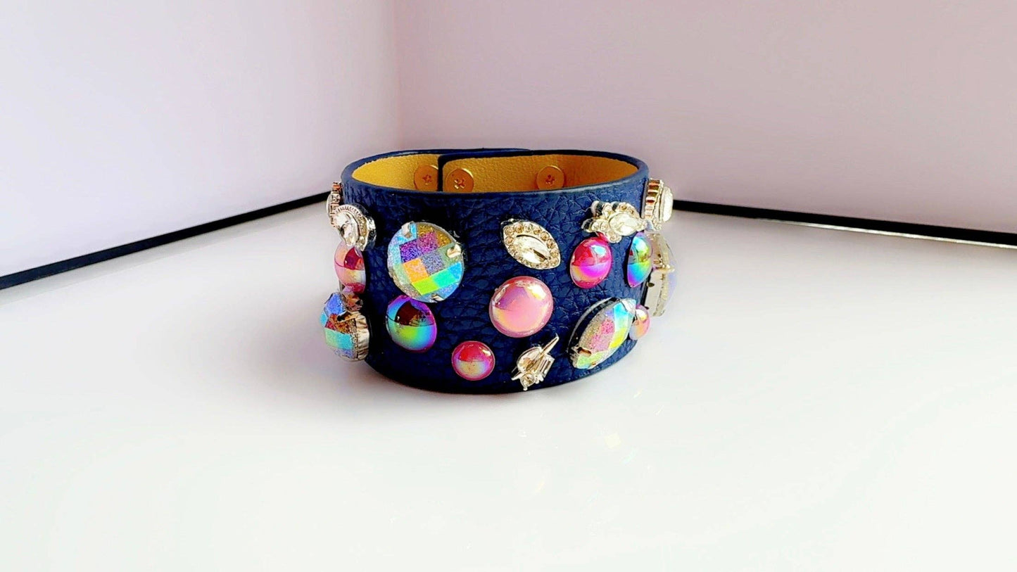 Decorative blue leather bracelet with colorful beads on a white surface