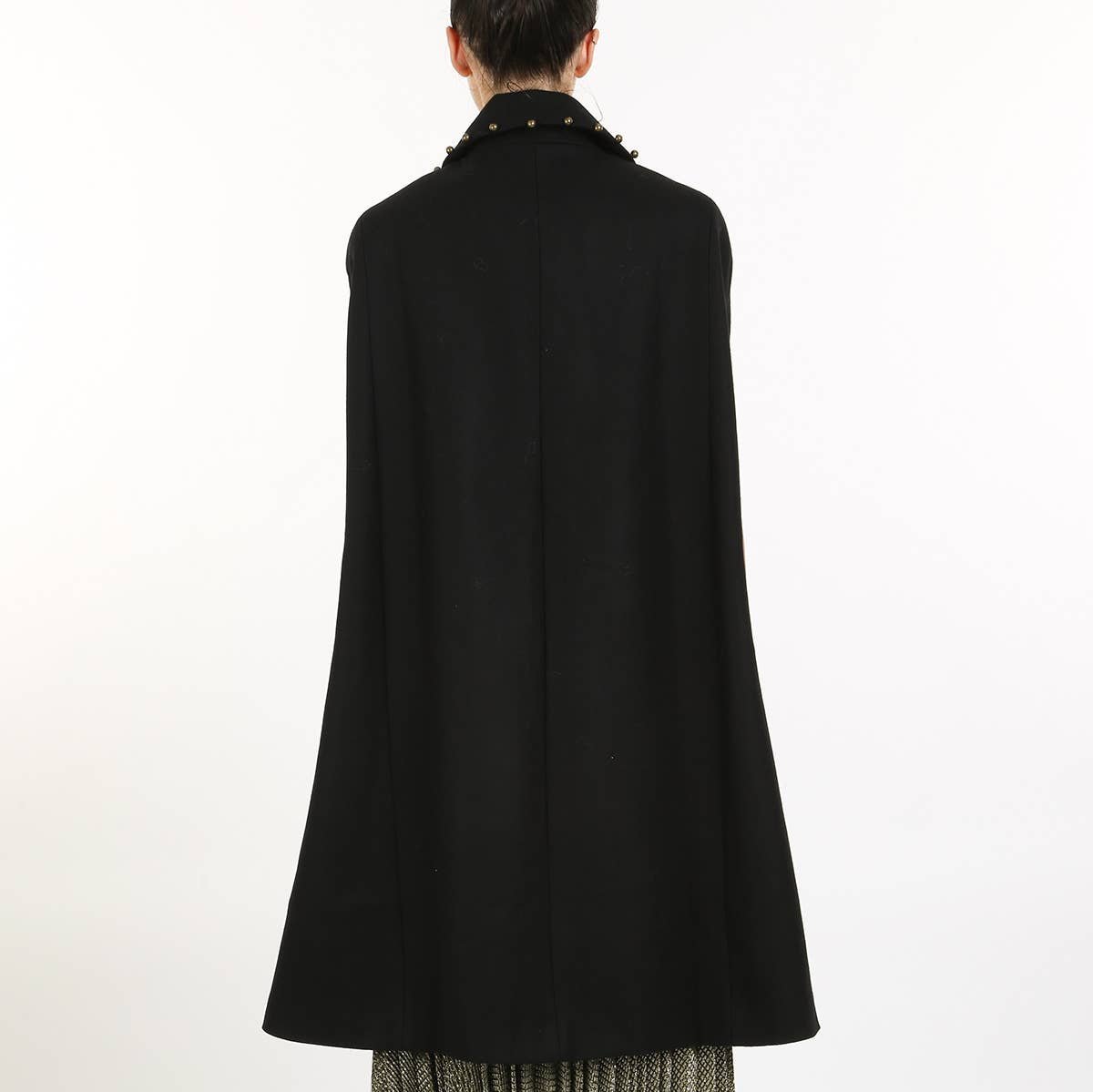 back view of a woman wearing a black cape coat against a white background