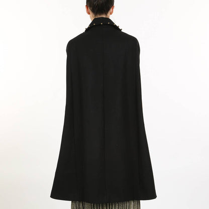 back view of a woman wearing a black cape coat against a white background