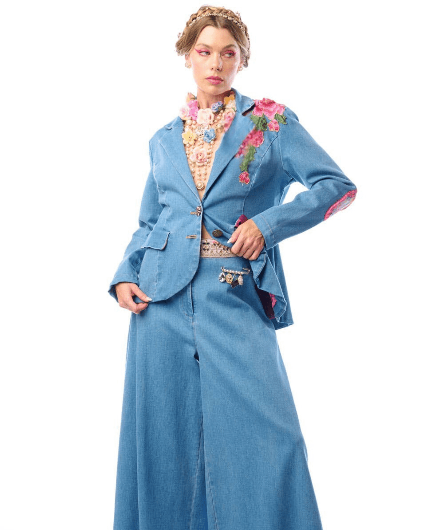 a woman wearing a blue denim jacket with floral embroidery against a white background