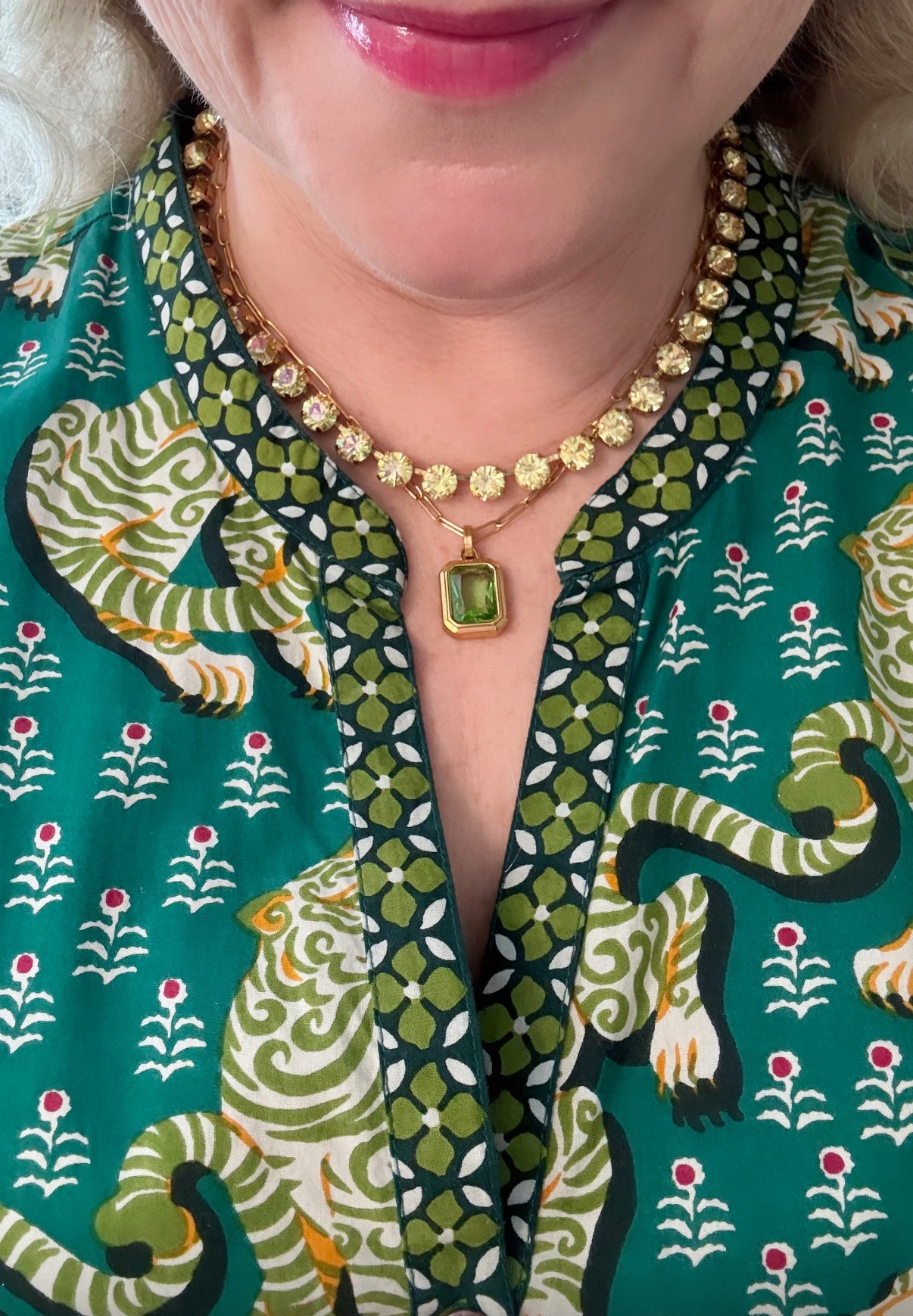 Woman wearing green stone pendant necklace with patterned top