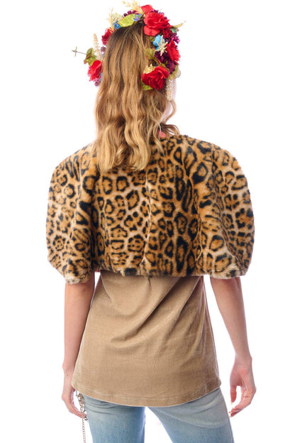 Back view of woman wearing a faux fur leopard print cape with a floral headpiece on a white background