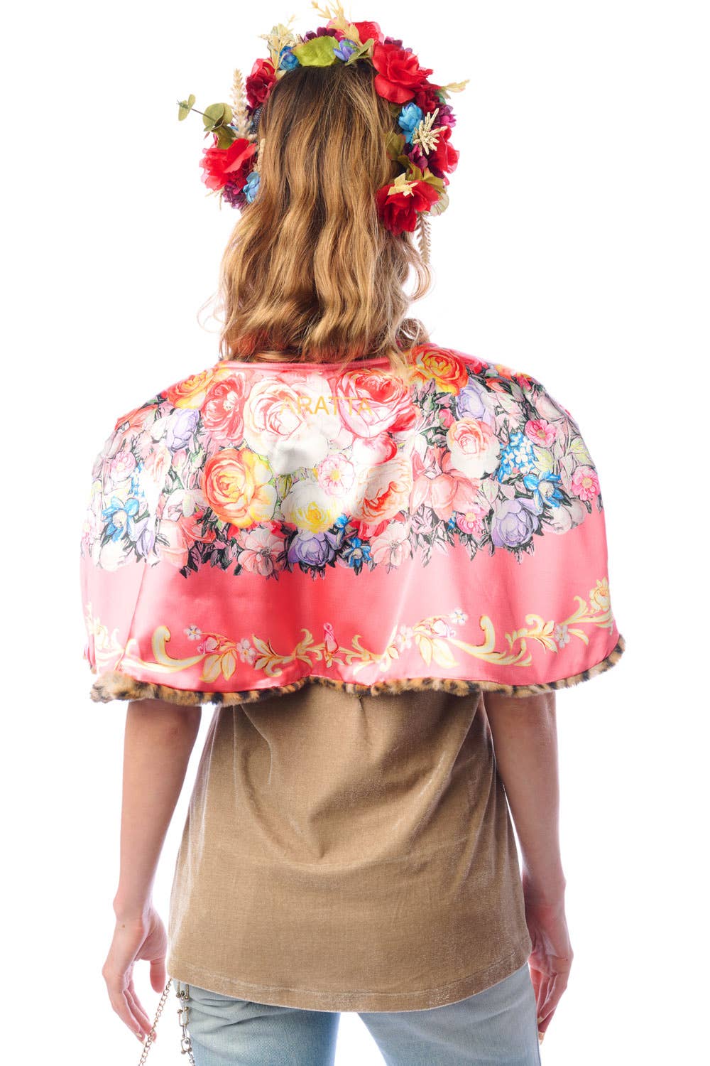 Back view of woman wearing a reversible floral cape with a white background