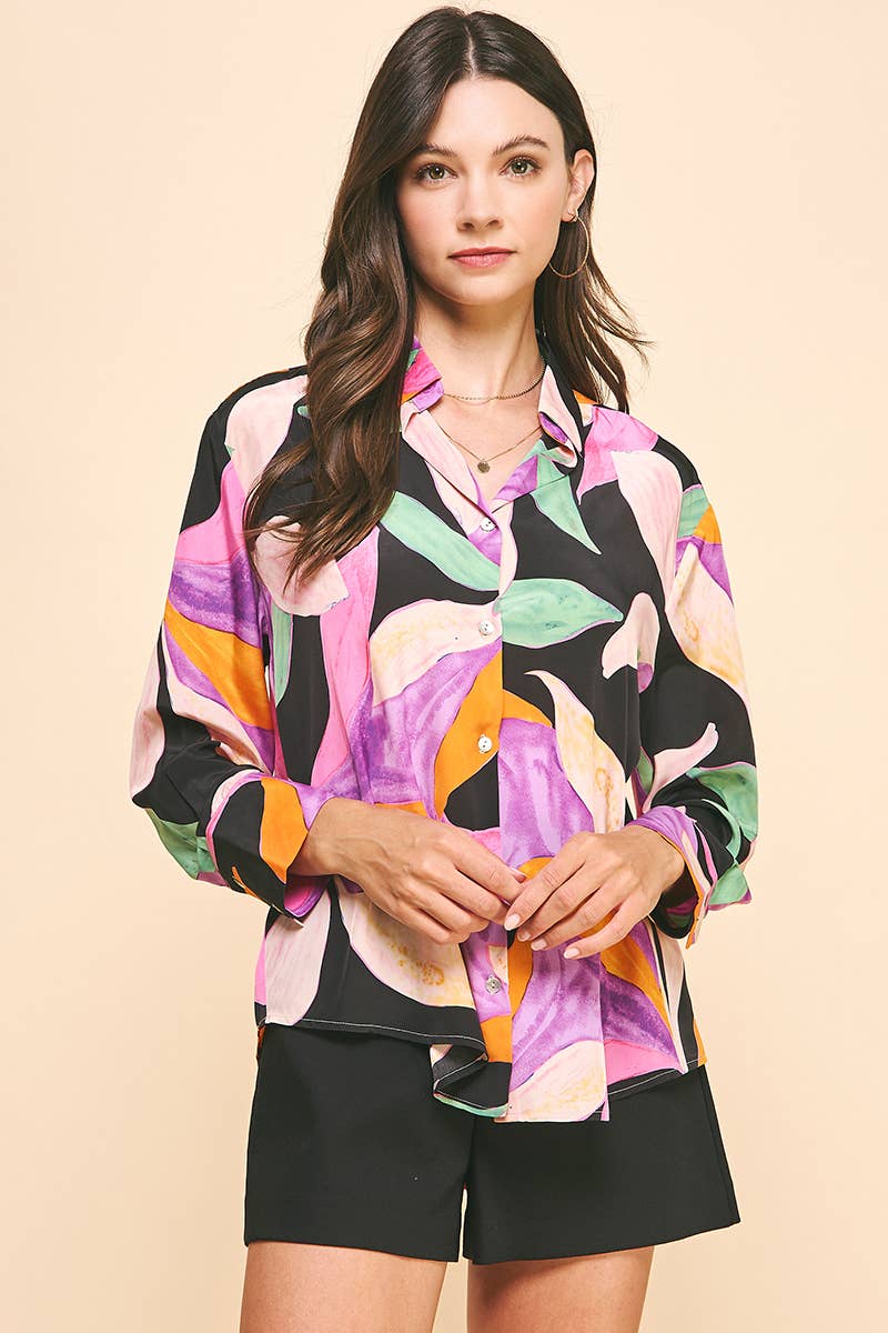 Woman wearing pink and purple floral button down blouse with black shorts