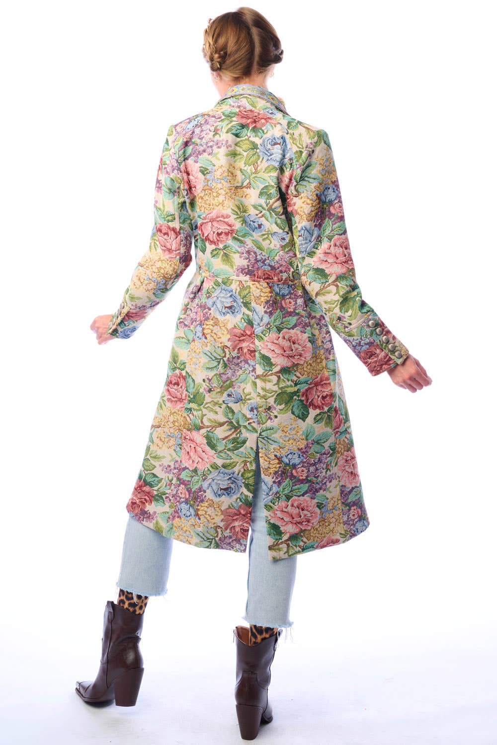 Back view of woman wearing a colorful floral coat on a white background