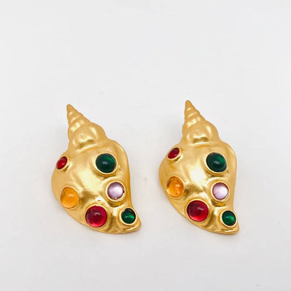 gold conch earrings with inlaid multi-colored glass against a white background