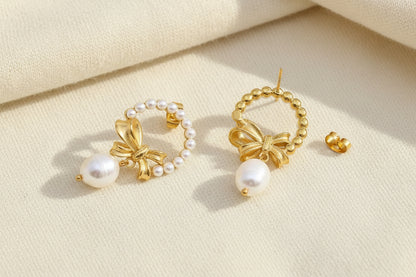Gold bow and pearl wreath earrings with one showing the back post detail against a grey textured background