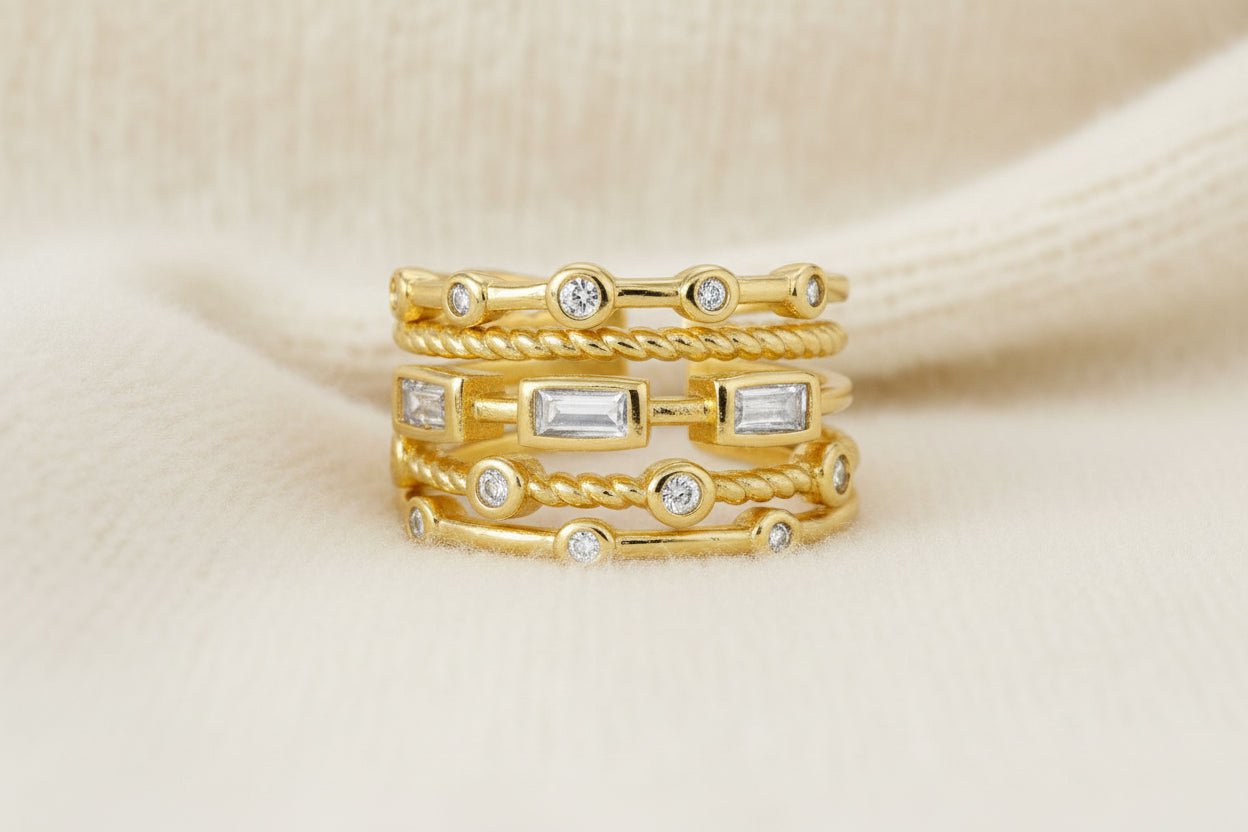 A gold stackable look ring with diamond accents on an ivory background