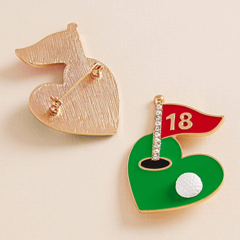 Two pins on a beige background, one showing the back pin closure and the other resembling a golf course with a ball and flag.