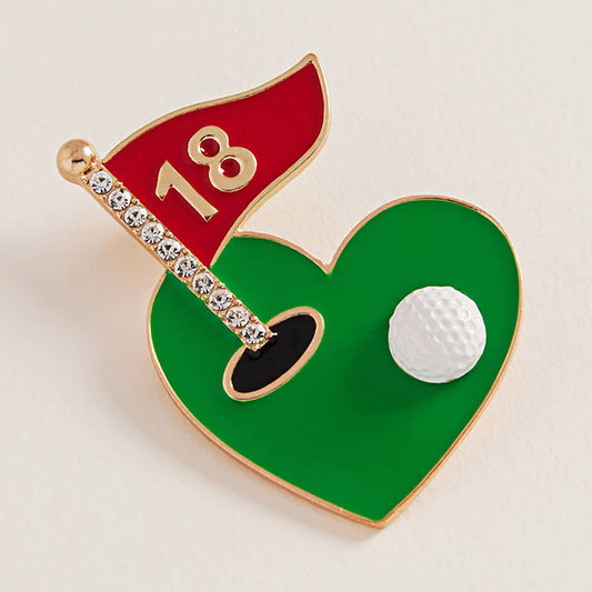 Heart-shaped golf accessory with a red flag, number 18, and golf ball on a beige background