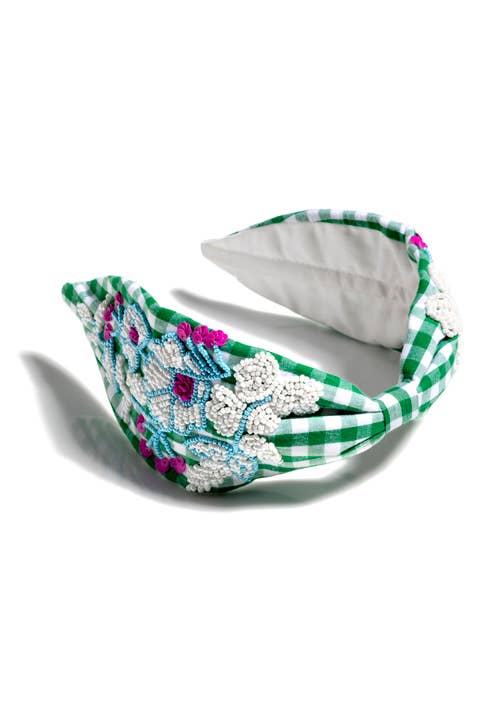 Green and white gingham knotted headband with hand-beaded floral embellishments on white background