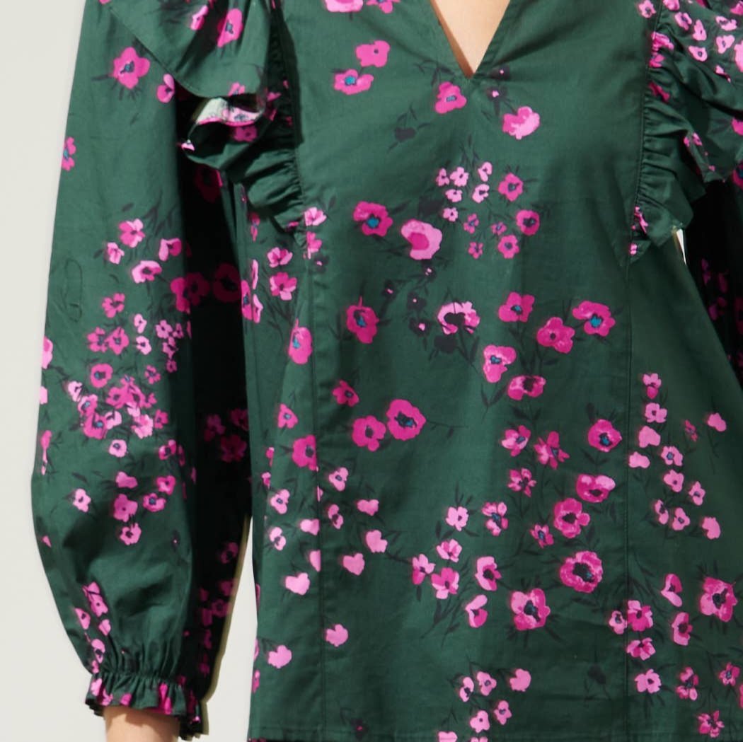 Close up view of a dark ruffled top with pink flowers