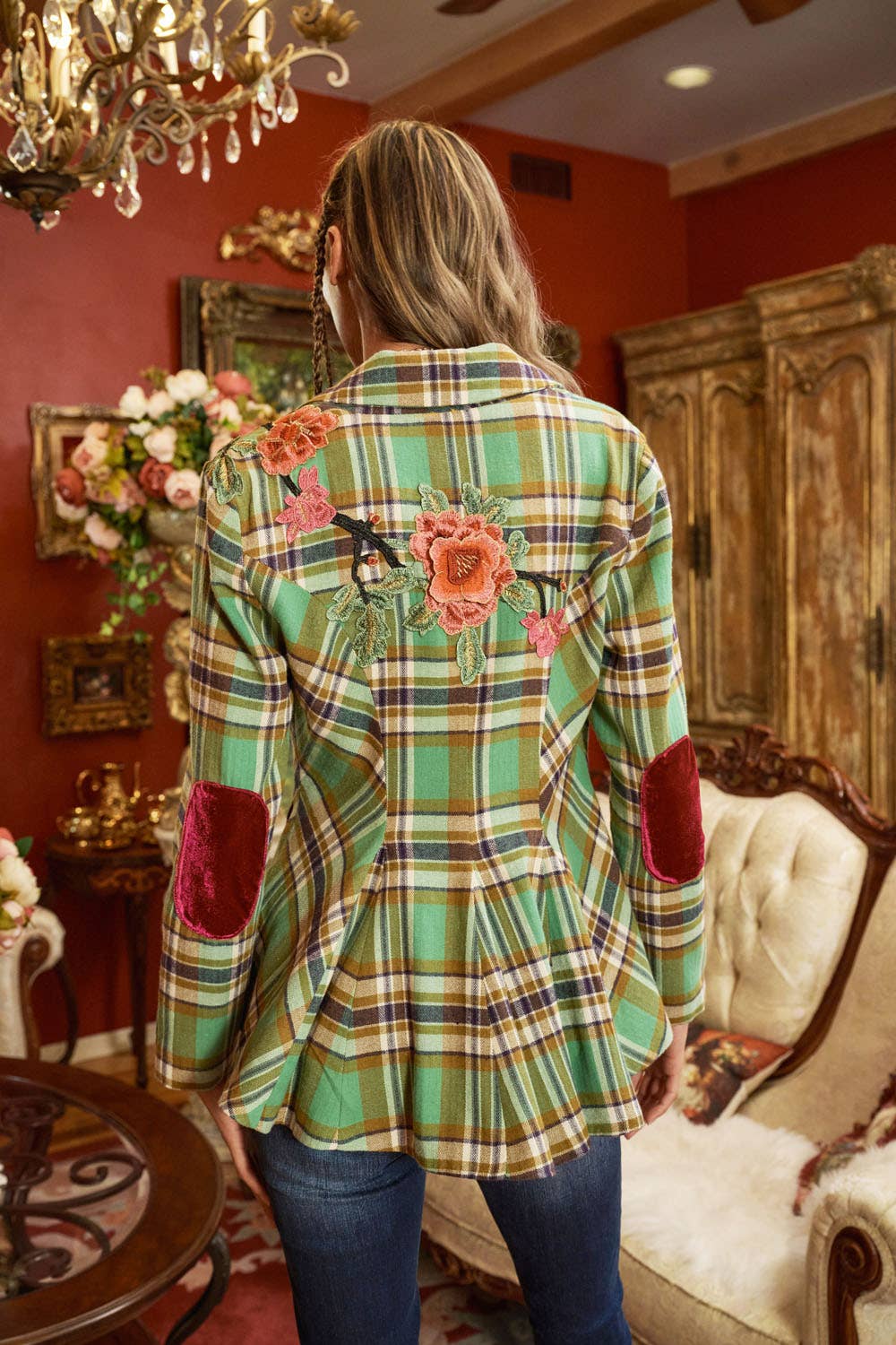 back view of woman wearing green plaid blazer with floral embroidery and jeans