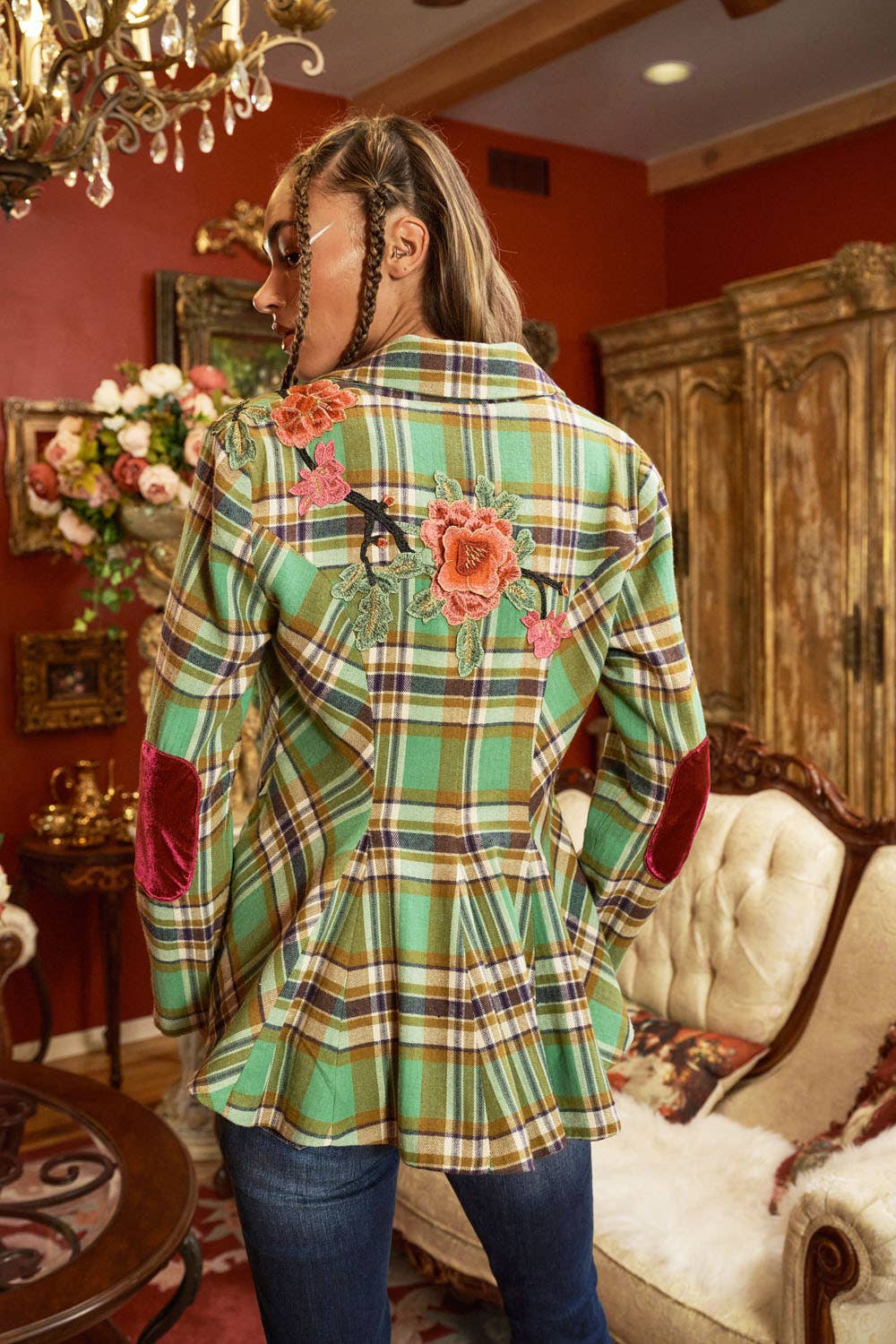 back view of woman wearing green plaid blazer with floral embroidery and jeans