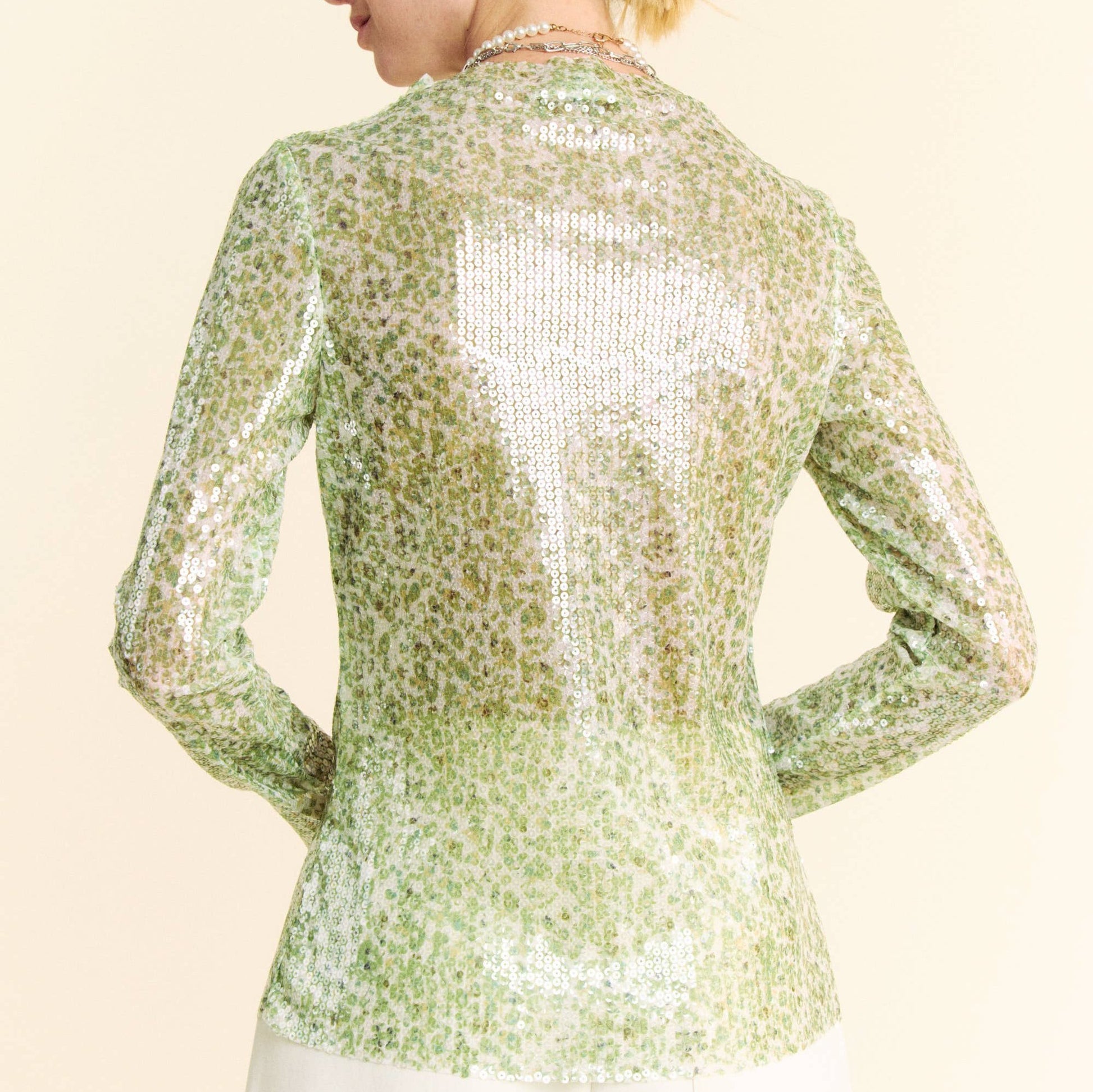 the back of a woman wearing a green sequin top
