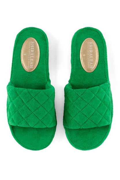 A pair of green quilted terry cloth pool slides with a rubber-like sole against a white background