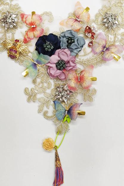 Close-up of handmade lace bib necklace showing crystal brooches and fabric flowers