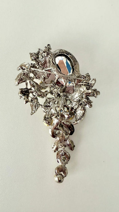 Back view of decorative brooch showing pin closure on a light gray background