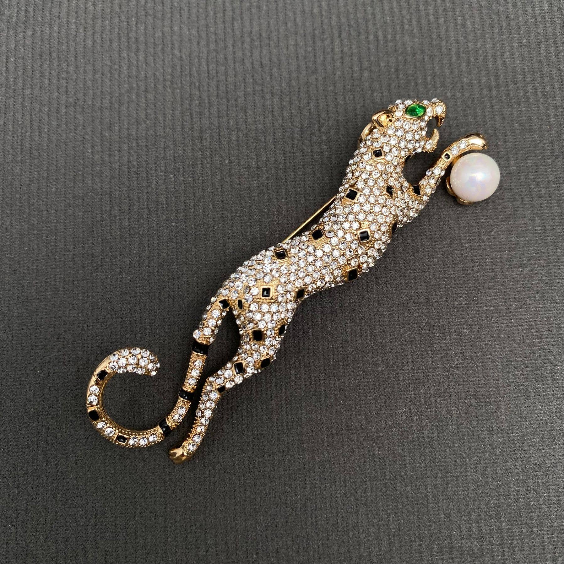 Jeweled leopard brooch with a pearl on a gray background