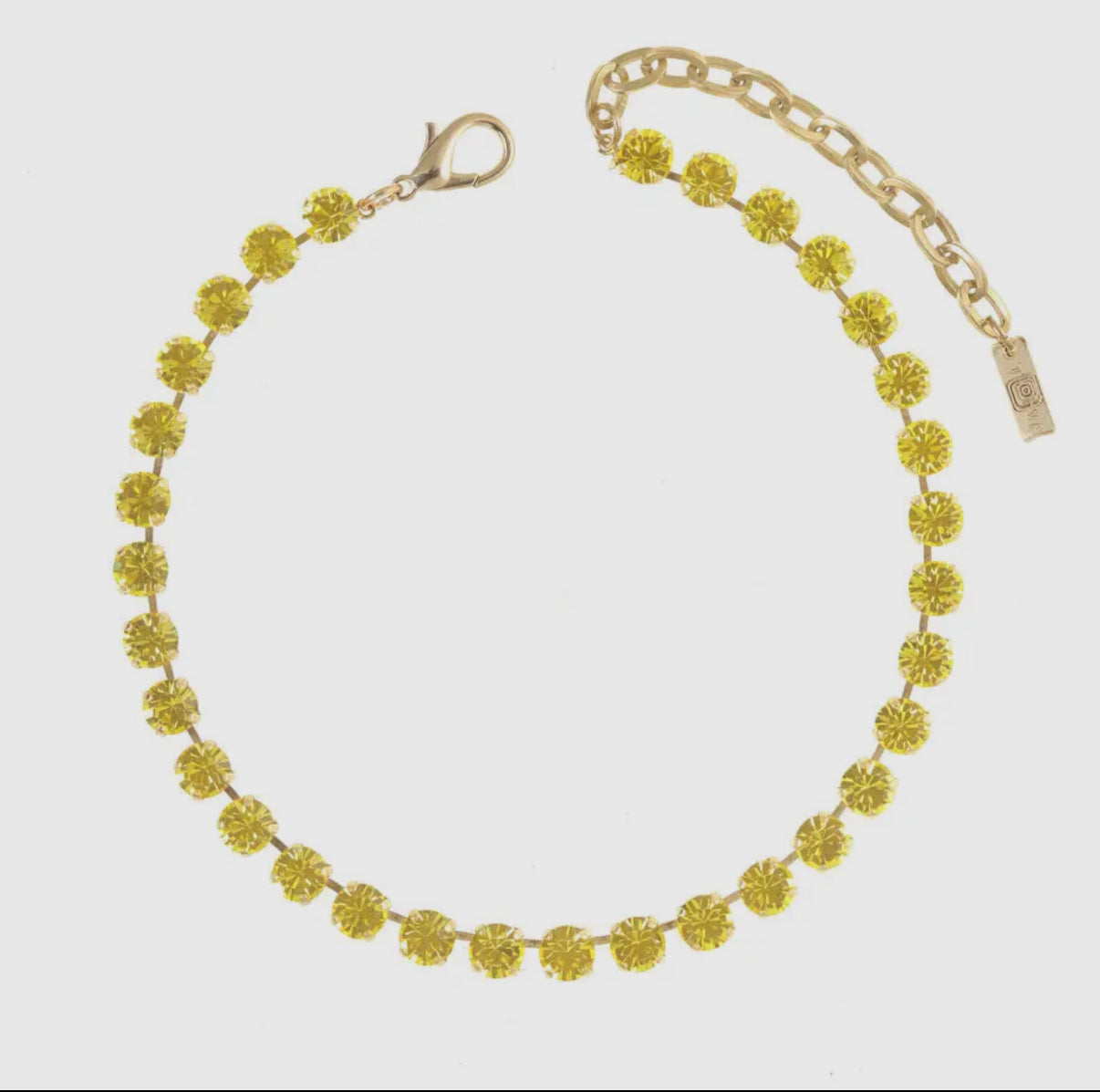 Lemon chiffon crystal necklace with antique gold setting on white background