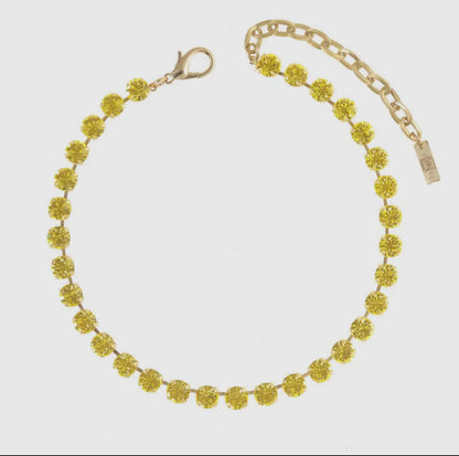 Lemon chiffon crystal necklace with antique gold setting on white background