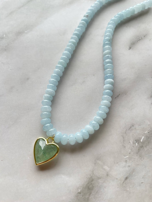 light blue gemstone bead necklace with gold and green heart charm