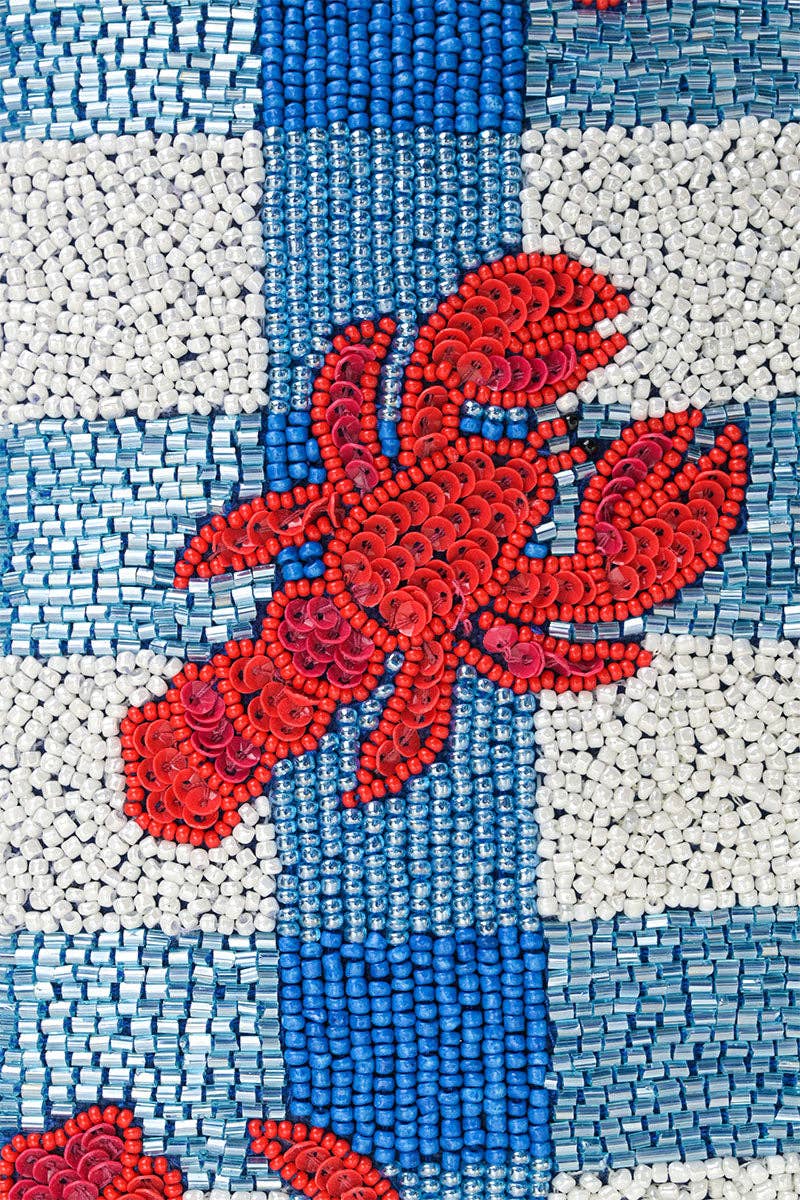 close up of red sequin lobster on blue and white beaded background