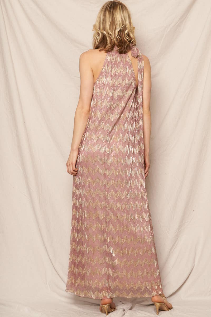 Back view of a woman in a chevron patterned dress in front of an ivory background