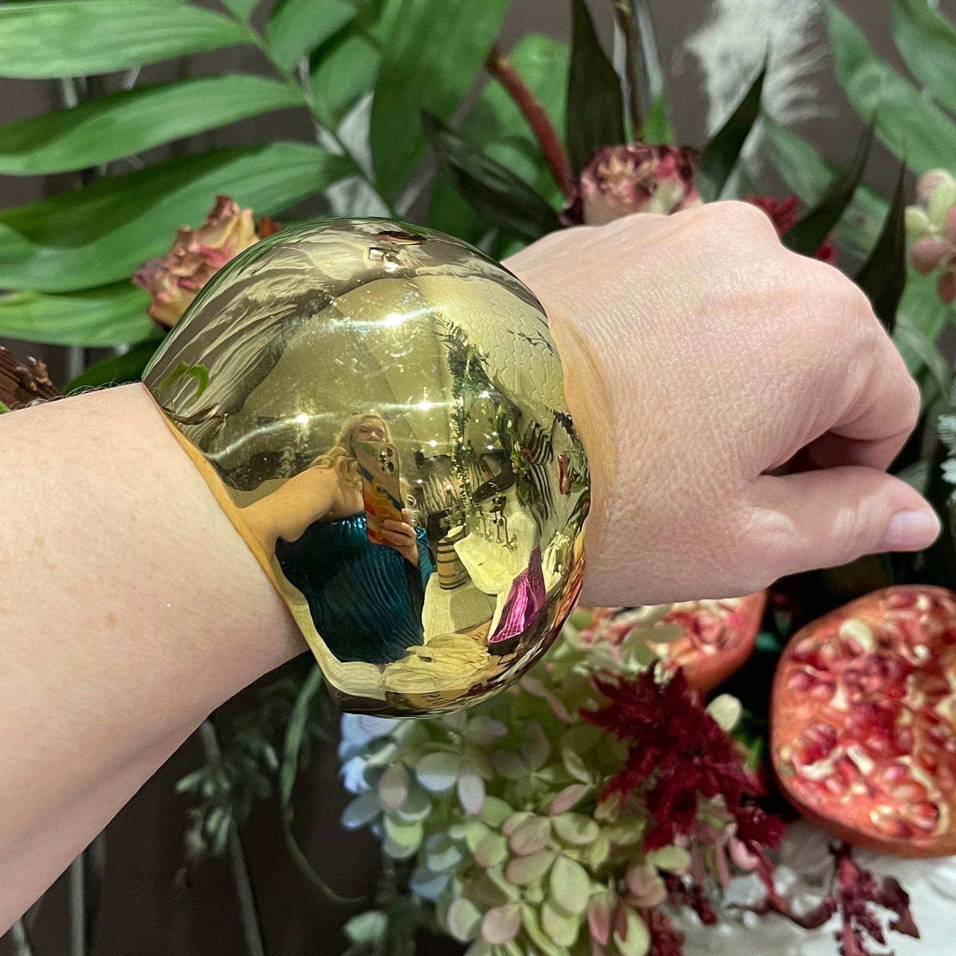 A woman’s arm wearing a brass dome shaped cuff