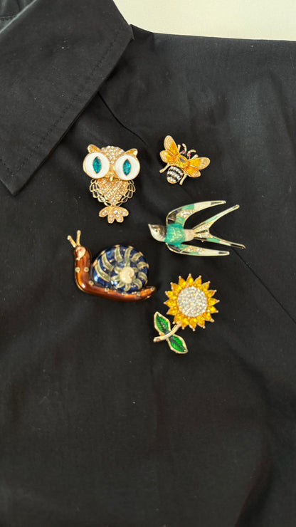 Collection of decorative pins on a black shirt