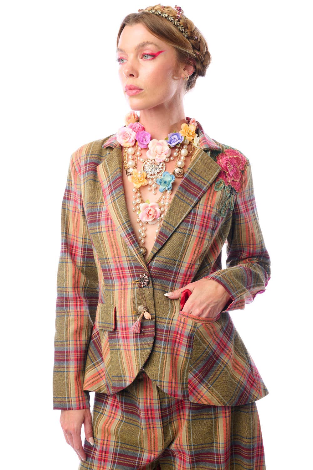 Person wearing a plaid suit with floral accessories on a white background