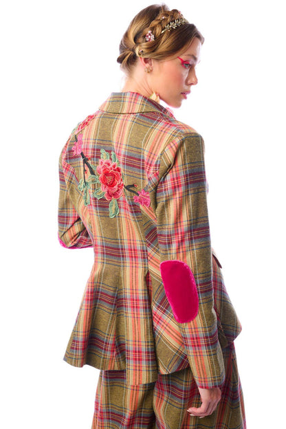 Angled view from the back of a woman wearing a plaid jacket with floral embroidery on a white background