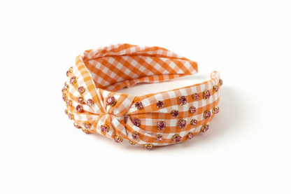 Orange and white gingham headband with pink rhinestones on a white background