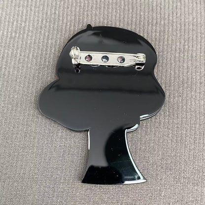 Back view of woman acrylic brooch on a textured gray background