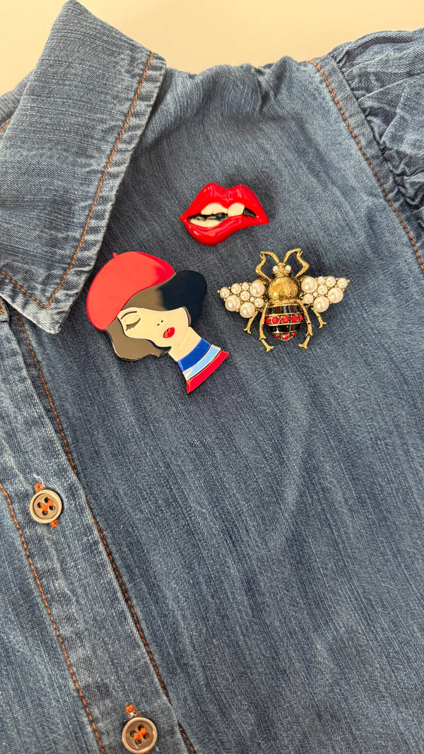 Emily in Paris brooch set with French girl red lips and pearl bee pins on denim shirt