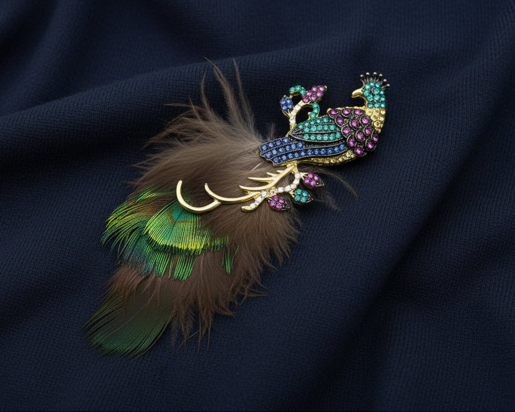 Decorative peacock brooch with crystals and feathers and gemstones on a navy fabric background