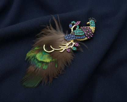 Decorative peacock brooch with crystals and feathers and gemstones on a navy fabric background
