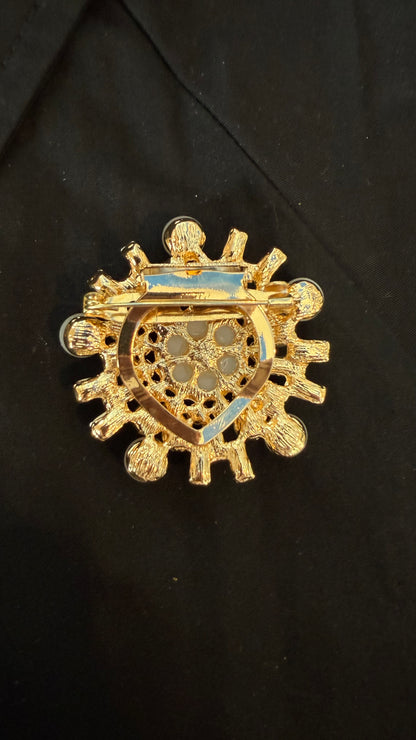 back view of brooch with intricate design on a black background