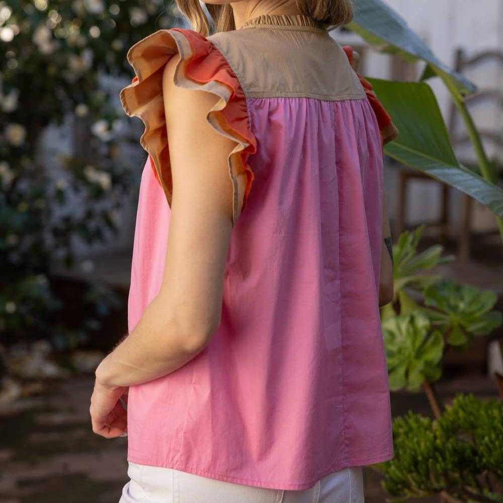 side view of a woman wearing a pink colorblock short sleeve blouse outside