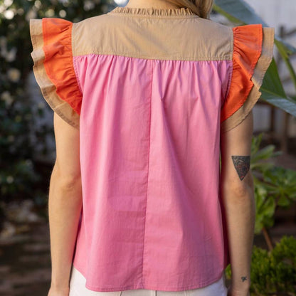 back view of a woman wearing a pink color block short sleeve blouse outside