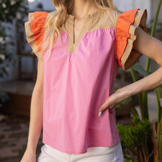 a woman wearing a pink colorblock short sleeve top outside