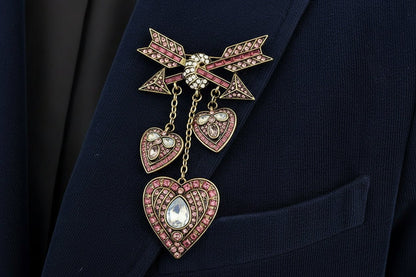 Decorative heart and arrows shaped brooch with pink gemstones on a navy corduroy blazer lapel