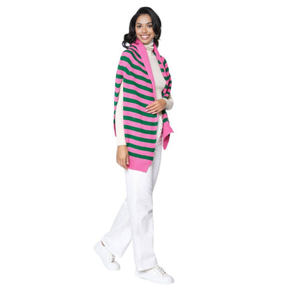 woman wearing pink and green stripe sweater scarf, white top, white jeans, and white sneakers in front of a white background