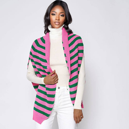 woman wearing pink and green stripe sweater scarf with white top and white pants in front of  white background