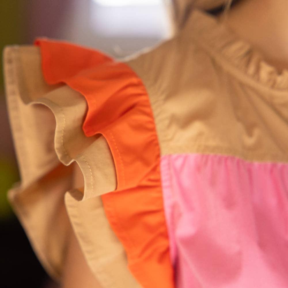 flutter sleeve detail of tan, orange, and pink dress