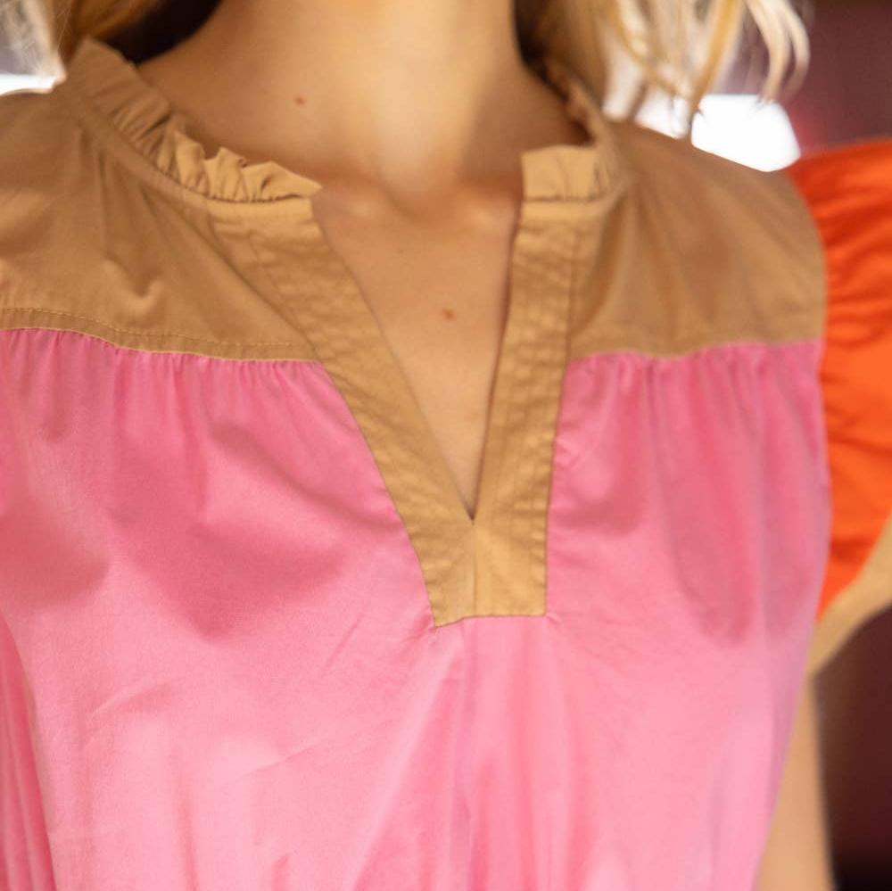up close detail of v-neckline on tan, pink and orange dress