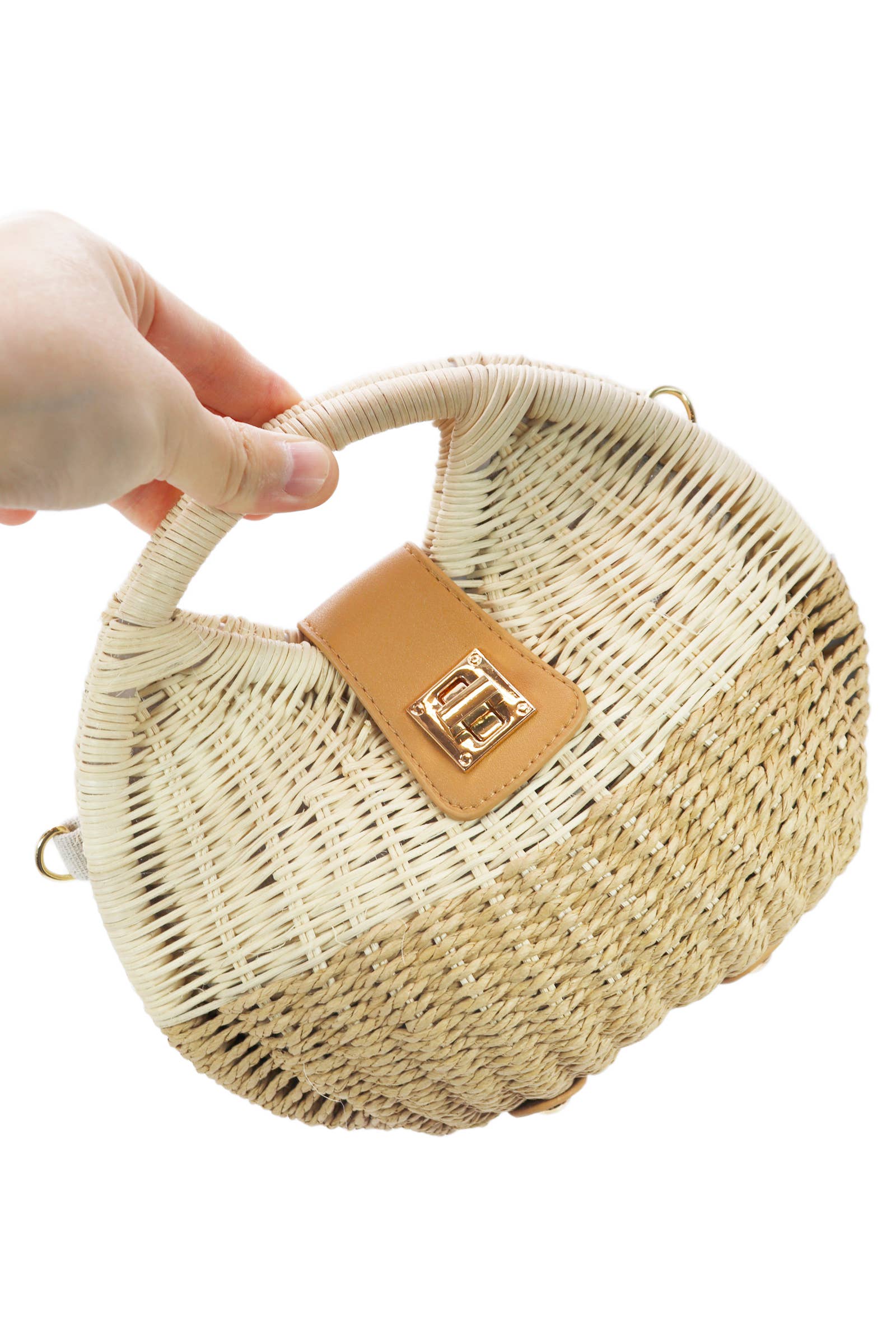 hand holding tan woven cross body bag with gold hardware